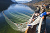 Fischer ziehen Netz aus Wasser