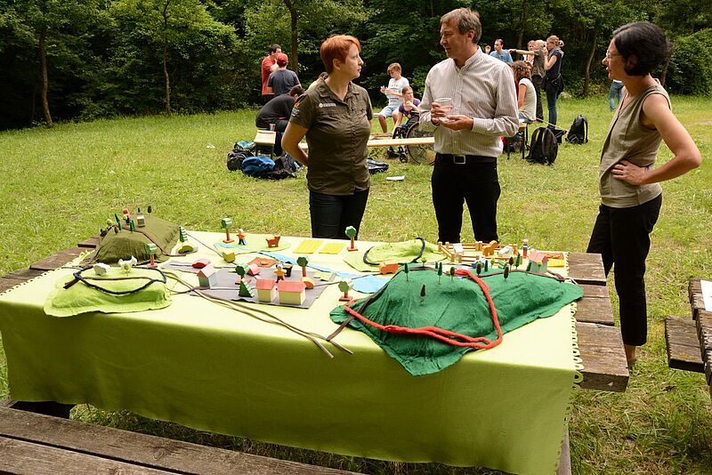 Regina Reiter vom BSP-Team der Bundesforste zeigt Biosphärenpark-Direktor Dr. Herbert Greisberger und Irene Szerencsics, Direktorin des Zentrums für Intensiv- und Sonderpädagogik in Purkersdorf, das Biosphärenparkspiel. (Credit: ÖBf/G.Waiss)