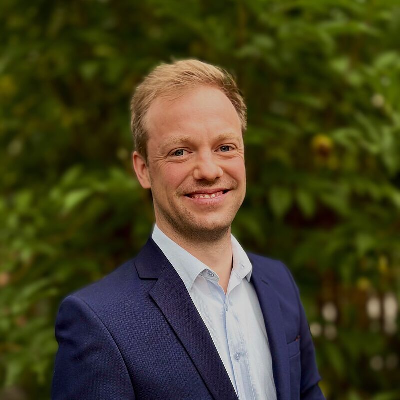 Michael Schickhofer, Landeshauptmann-Stellvertreter, lächelt vor grüner Kulisse